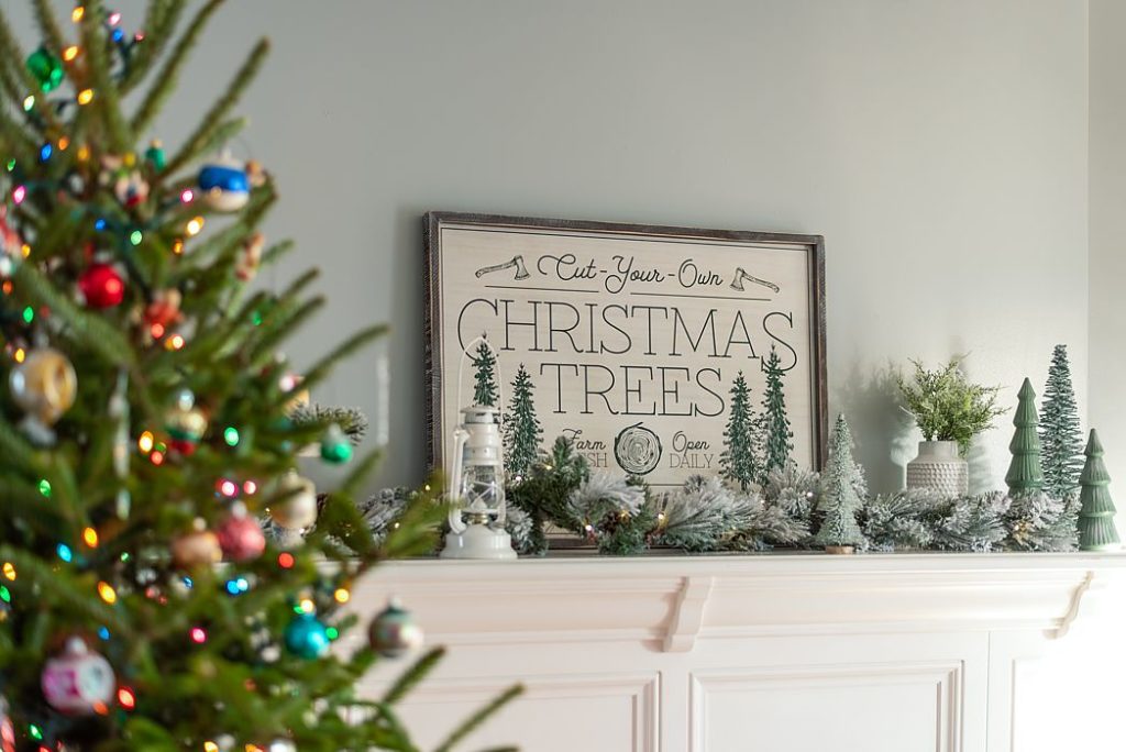 Simple garland and miniature Christmas trees adorn this simple mantel.